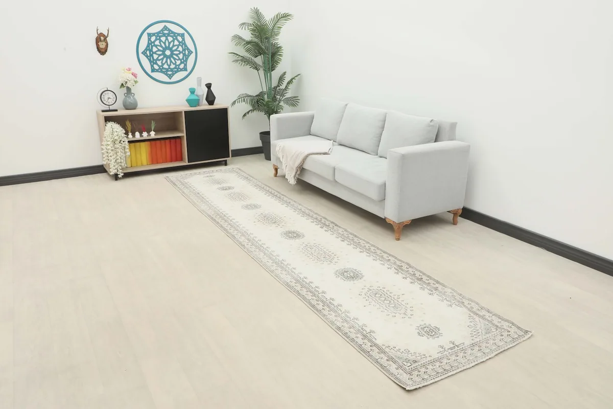 Ivory and gray runner rug displayed in a modern living space with a light gray couch and wooden furniture.
