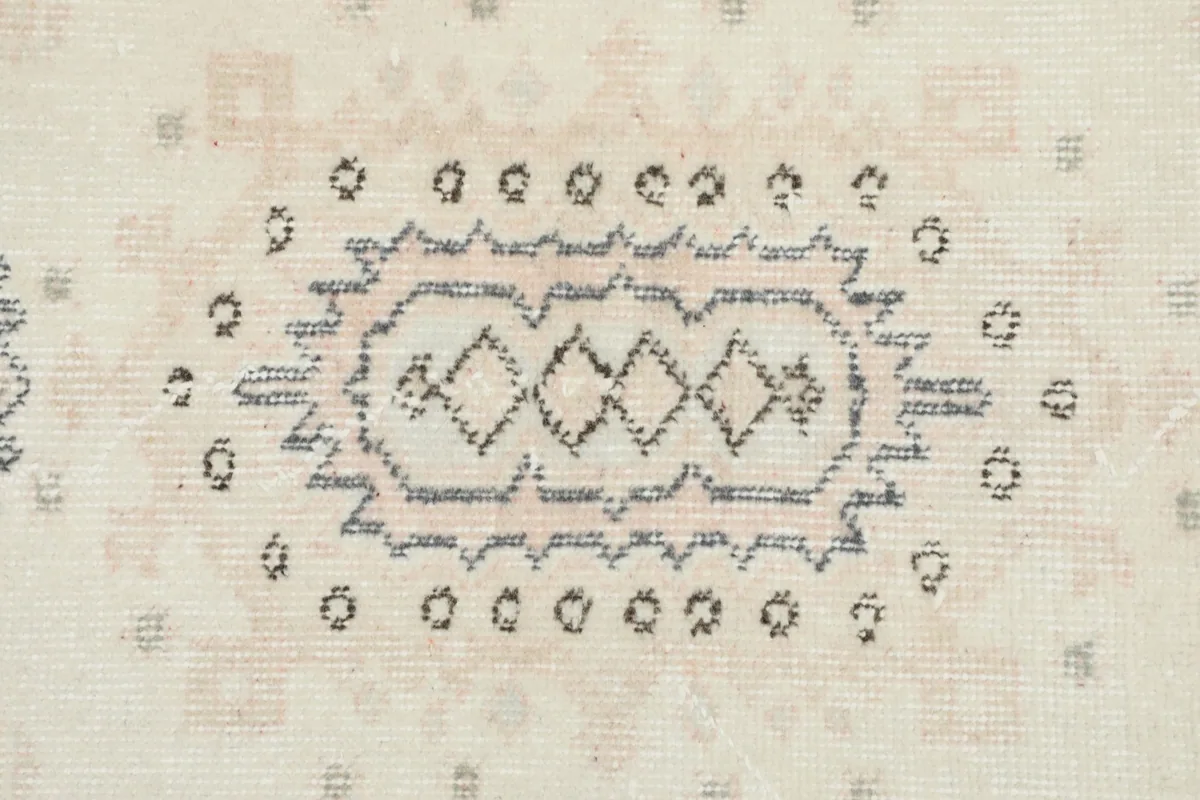 Macro detail of a central geometric motif, revealing the intricate weaving and colors within the pattern.