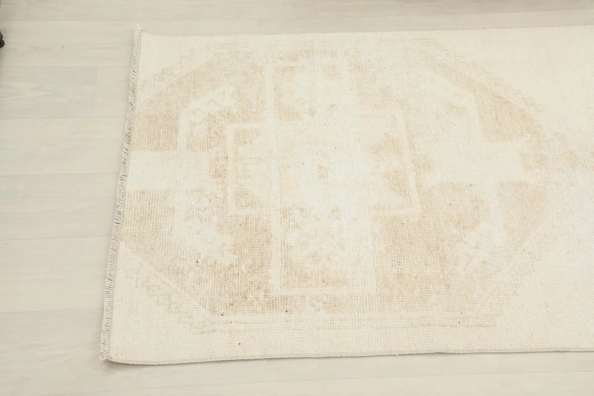 Close-up angle view of the other end of the beige runner, revealing subtle motifs