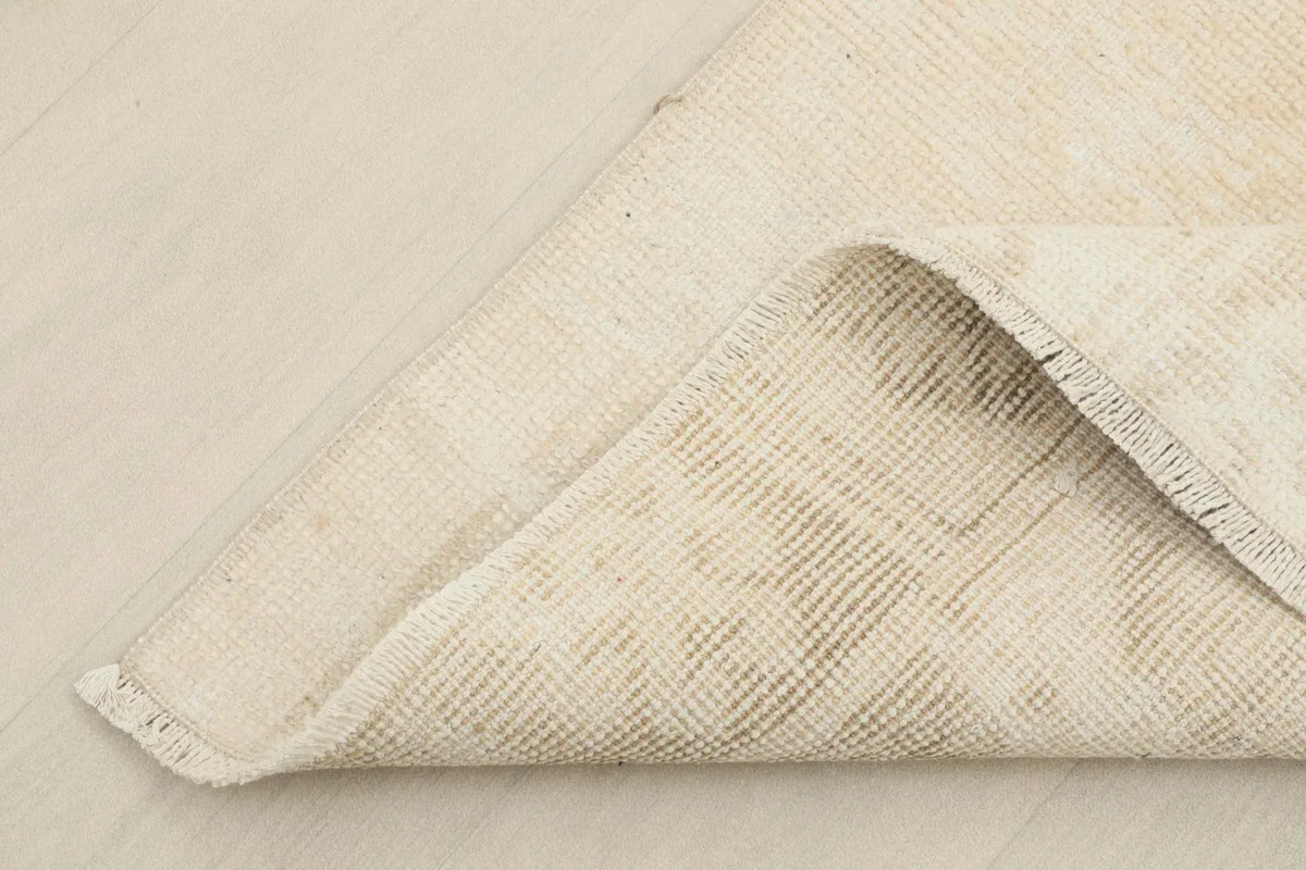 View of the back of the rug, showing the cotton foundation and hand-knotted construction