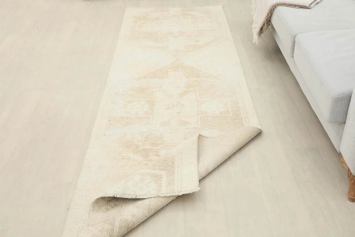 The beige runner partially folded, revealing both the pile side and the cotton foundation