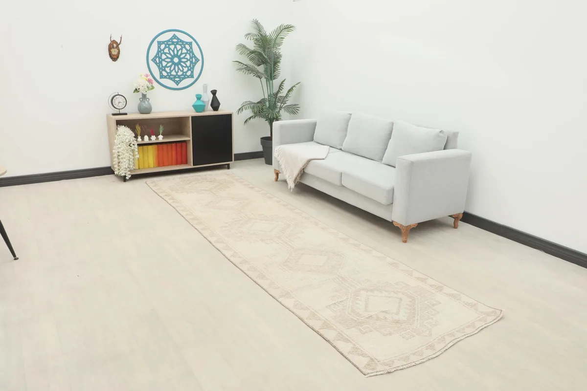 Long view of the runner rug in a room setting with a sofa and decor