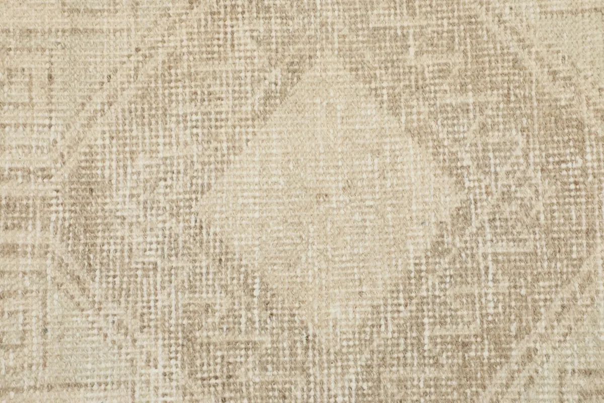 Detailed view of the wool pile and subtle color variations within a geometric design