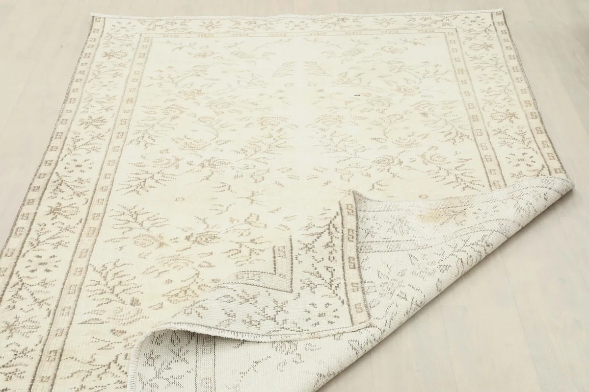 Rug with a corner folded back, showing the reverse side and overall pile.