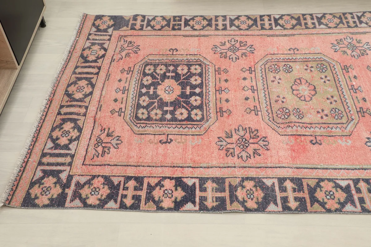Angled view of the runner's pattern, featuring a navy medallion and geometric border