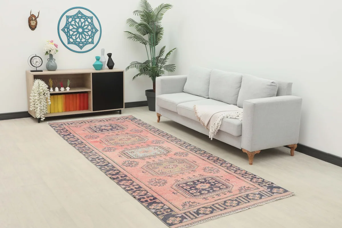 Long view of the rose and navy runner in a room, showing its scale and pattern alongside furniture