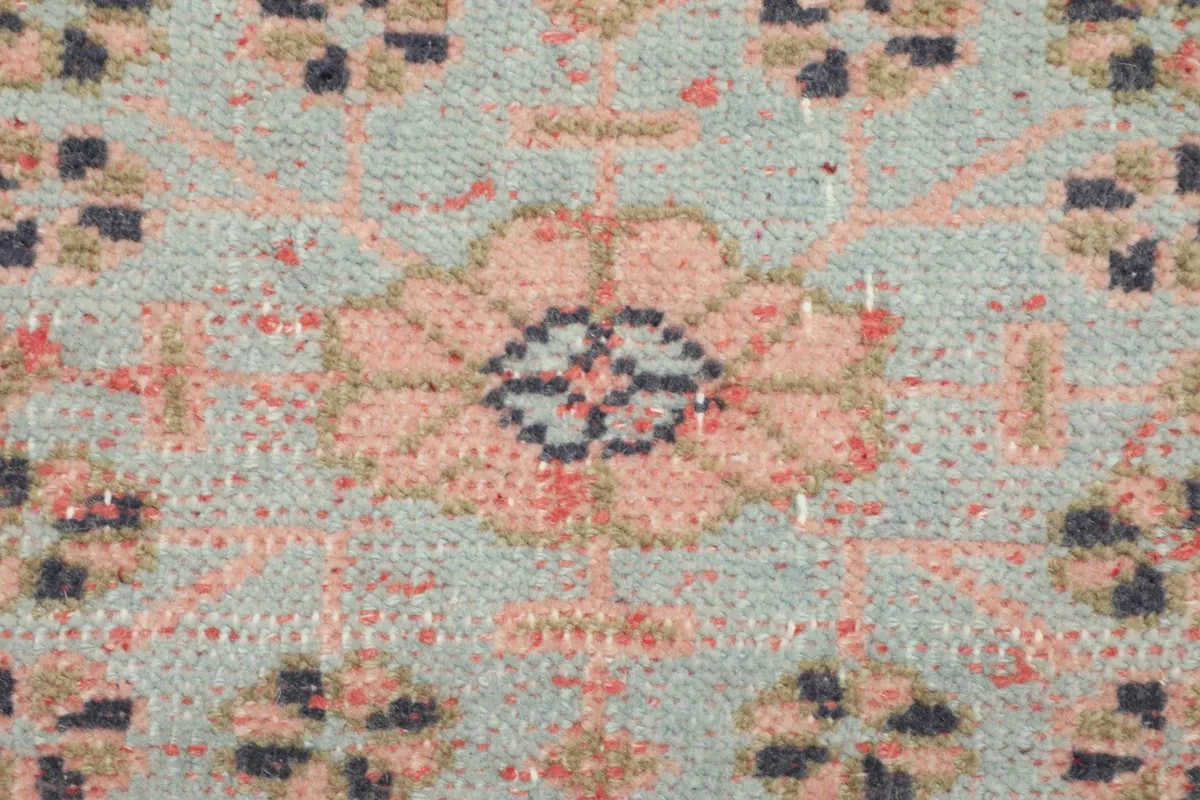 Macro detail of the hand-knotted wool pile, showing colors and texture of a central motif