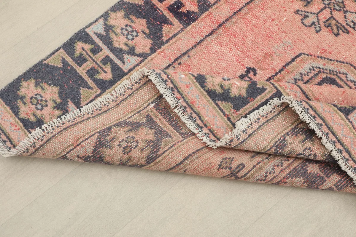 Corner of the runner folded back, revealing the cotton foundation and reverse side of the weave