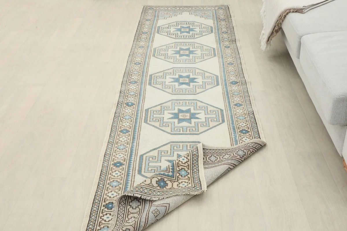Long view of the runner rug partially rolled, showcasing its length and pattern