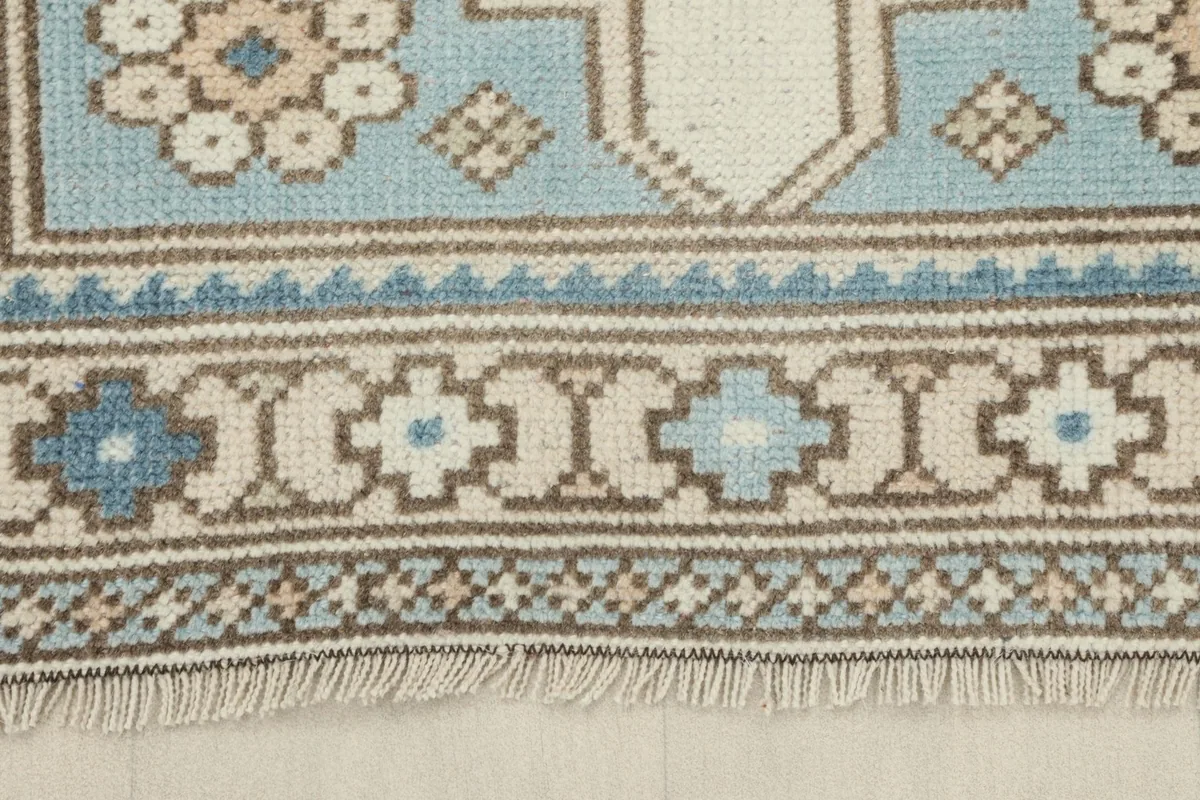 Close-up of the intricate border design and fringe on the vintage runner