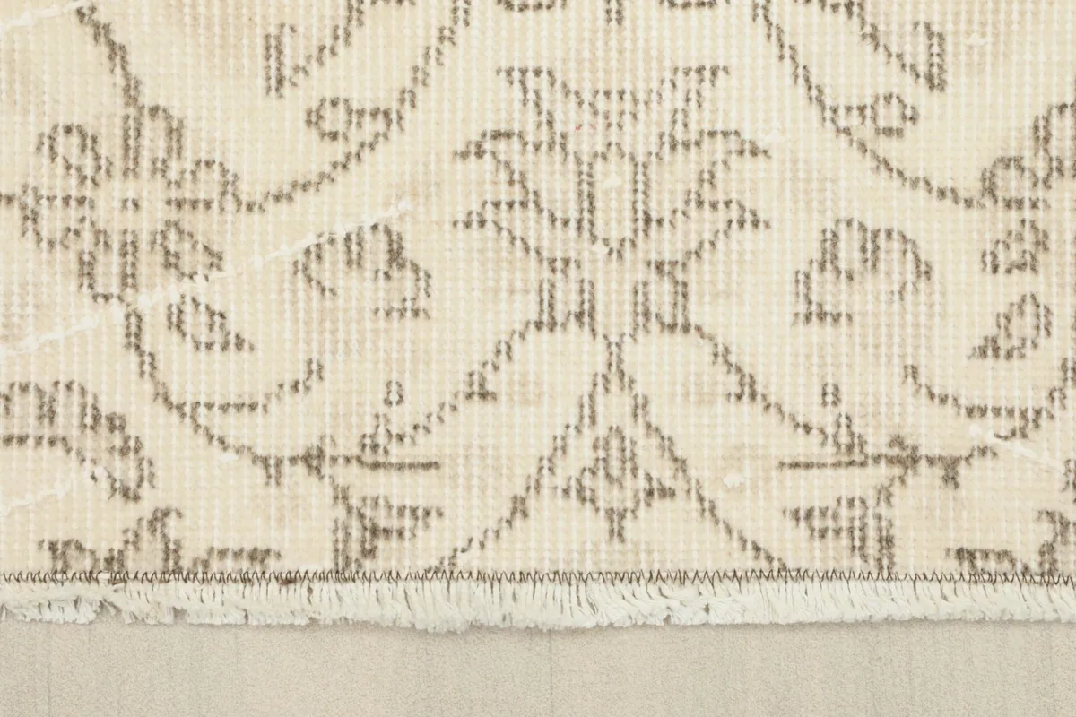 Close-up of the rug's short, natural fringes and the edge of the pattern.
