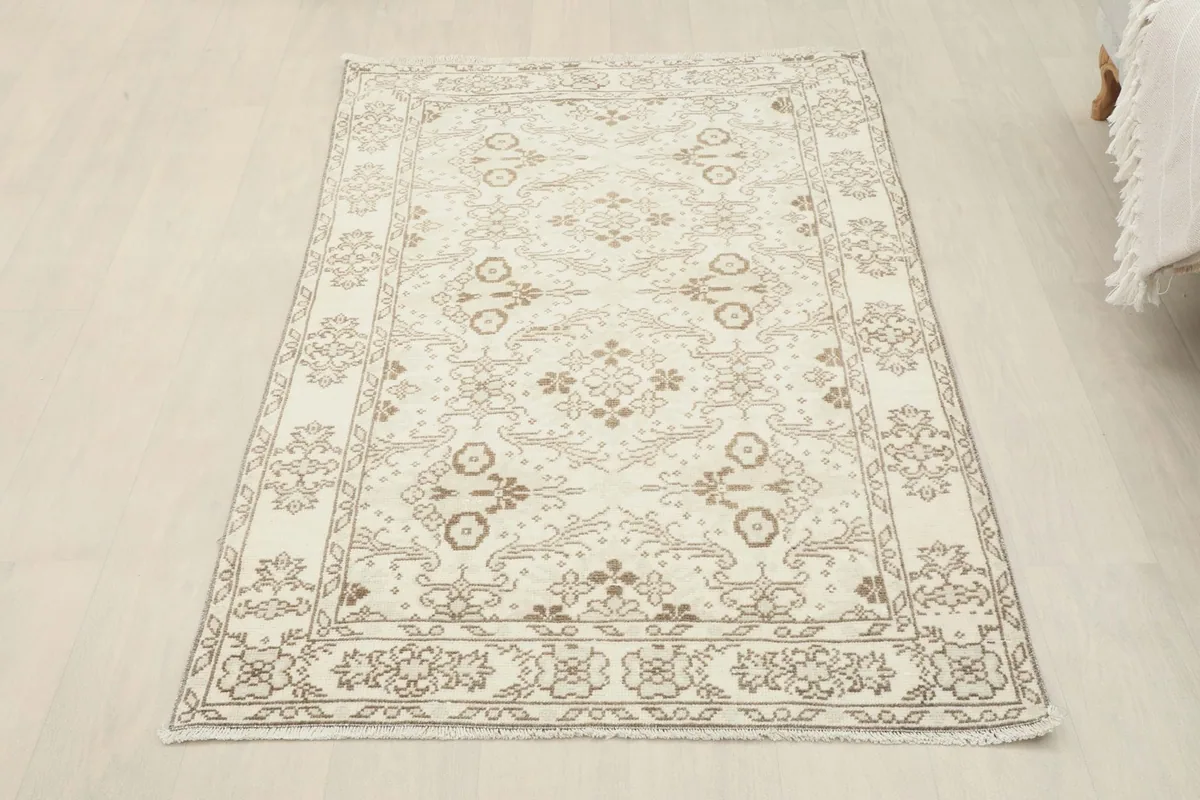 Full view of the rug in a room setting, positioned on light flooring next to a sofa.