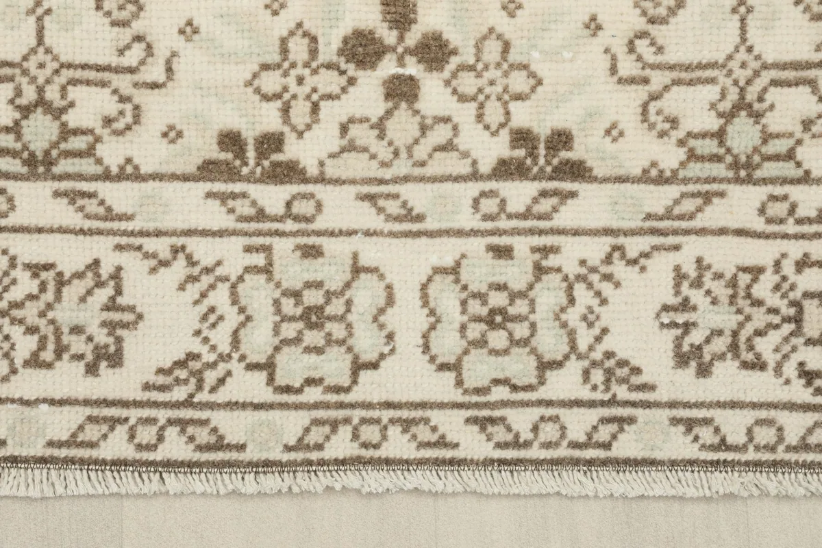 Close-up of the rug's border and fringe, showing the intricate weaving and colors.