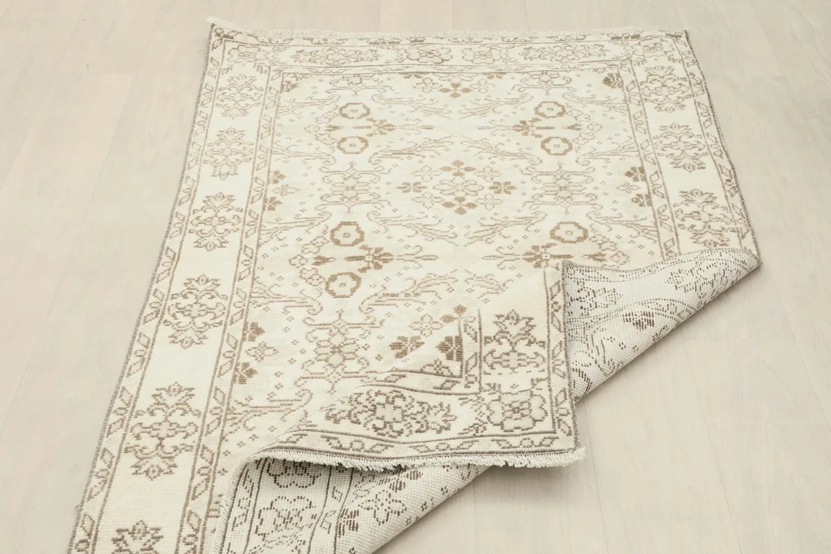 Rug partially folded to reveal the reverse side, showcasing the craftsmanship of the knots.