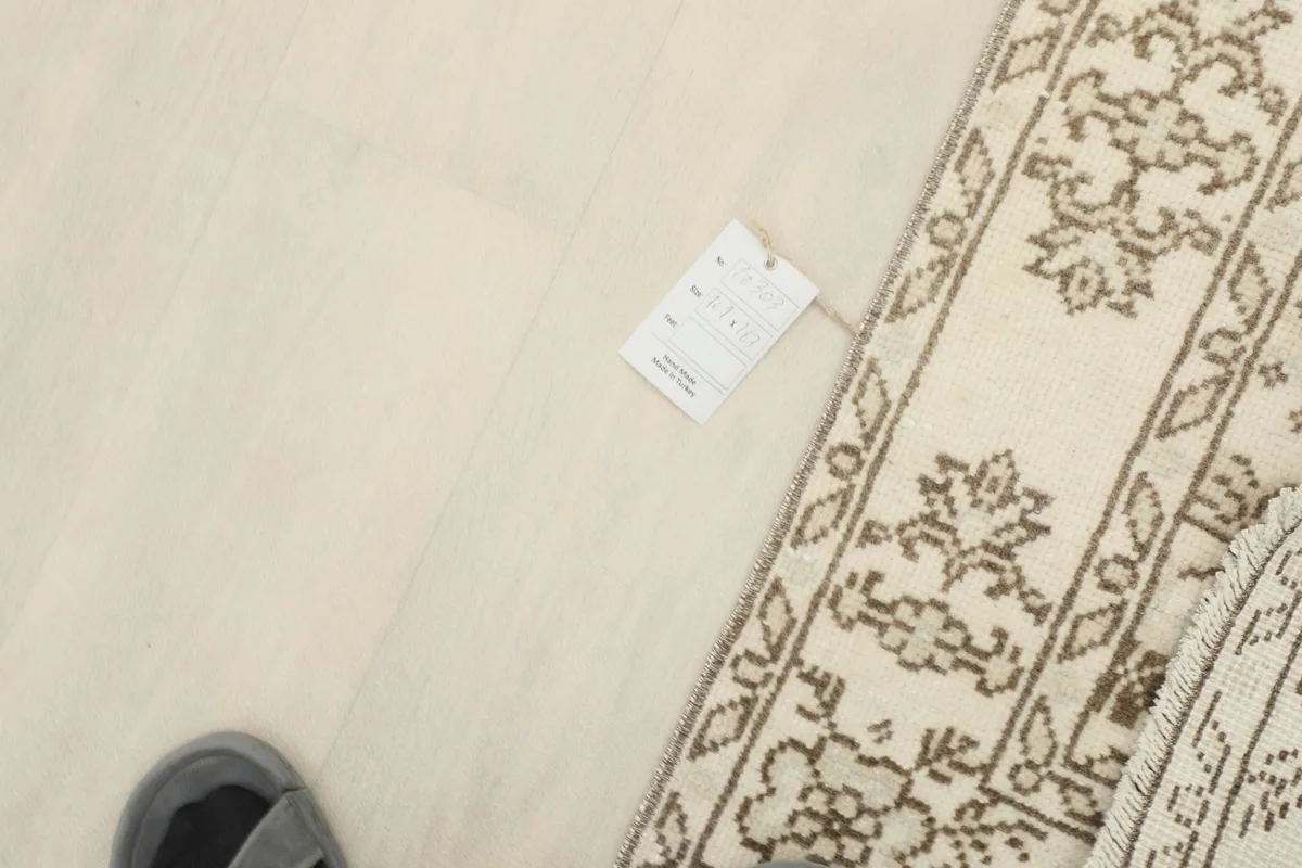 Overhead view showing a tag on the floor next to the rug, indicating product information.
