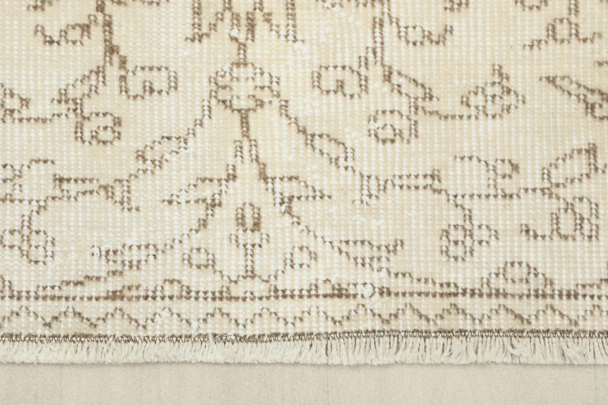 Detail of the rug's edge, showing the short fringe and the tightly woven border design