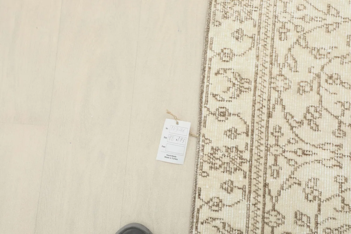 Overhead detail showing a tag near the rug's edge, indicating its origin and materials