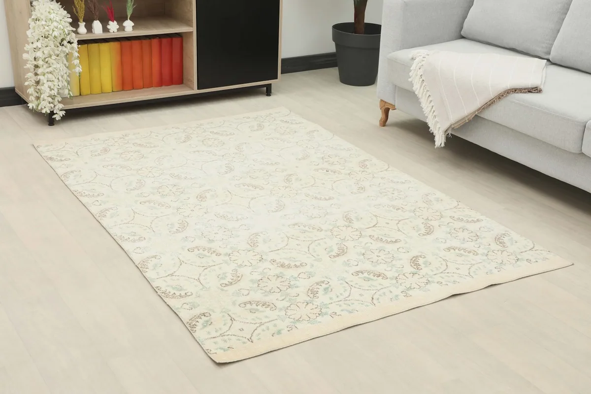 Area rug laid out in a modern living room setting, showing its scale next to a sofa and cabinet.