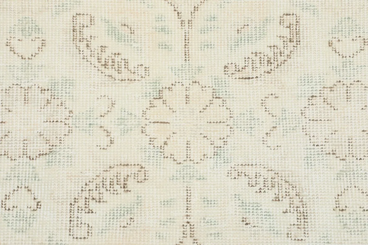 Macro shot of the hand-knotted wool pile, revealing the intricate floral design and texture.