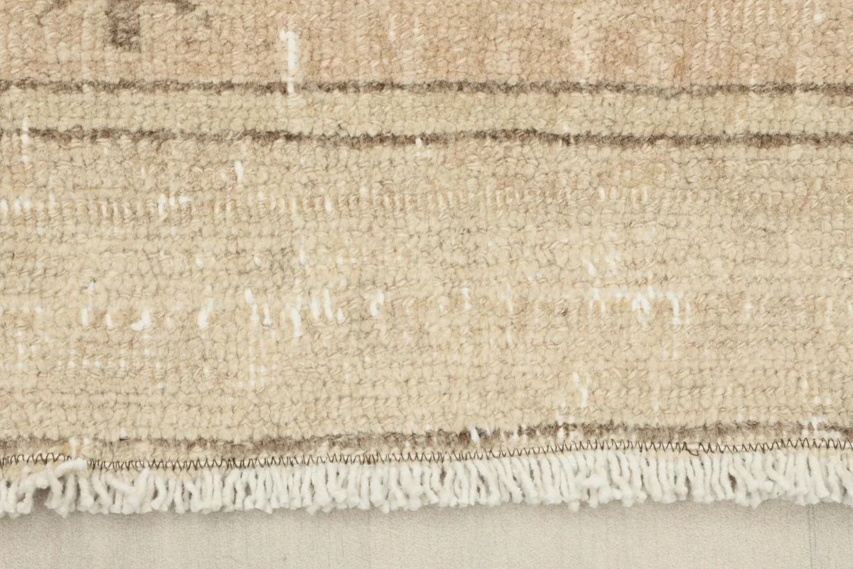 Close-up of the rug's short, natural fringe and the woven cotton foundation