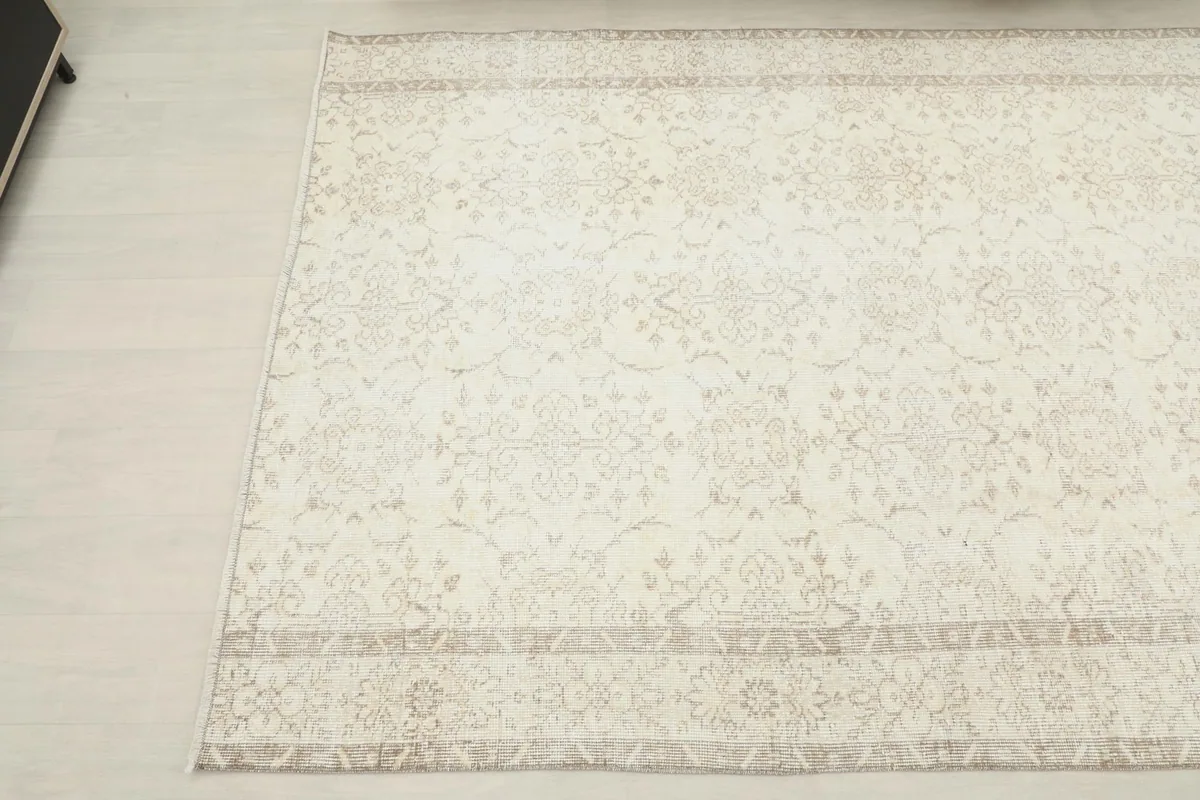 Overhead shot of the other end of the ivory and beige rug, capturing the full pattern repeat.