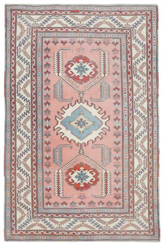 Full overhead view of the rose 7x11 vintage Anatolian rug with tribal medallions and geometric borders
