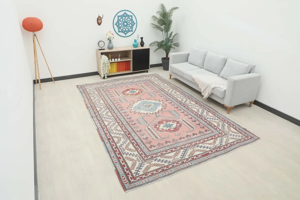 Large rose rug displayed in a modern living room setting with a light gray sofa