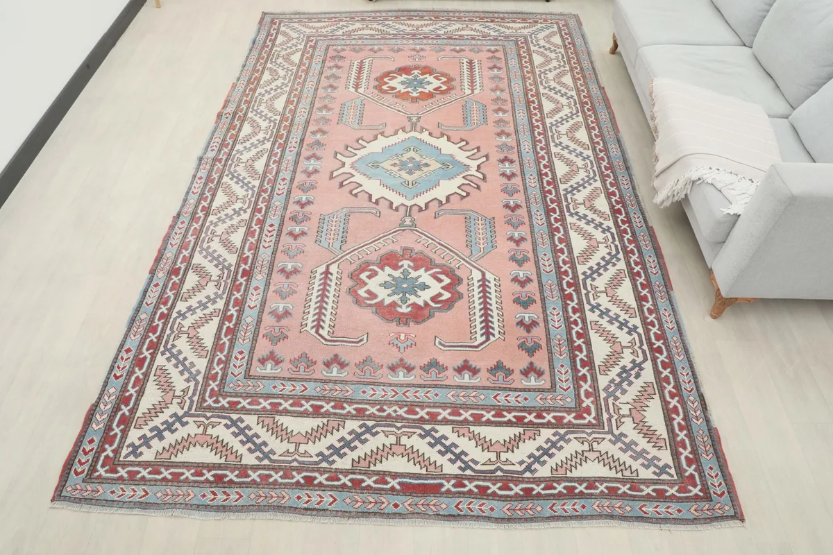 Overhead room view of the large rose rug with a sofa, providing a full sense of scale
