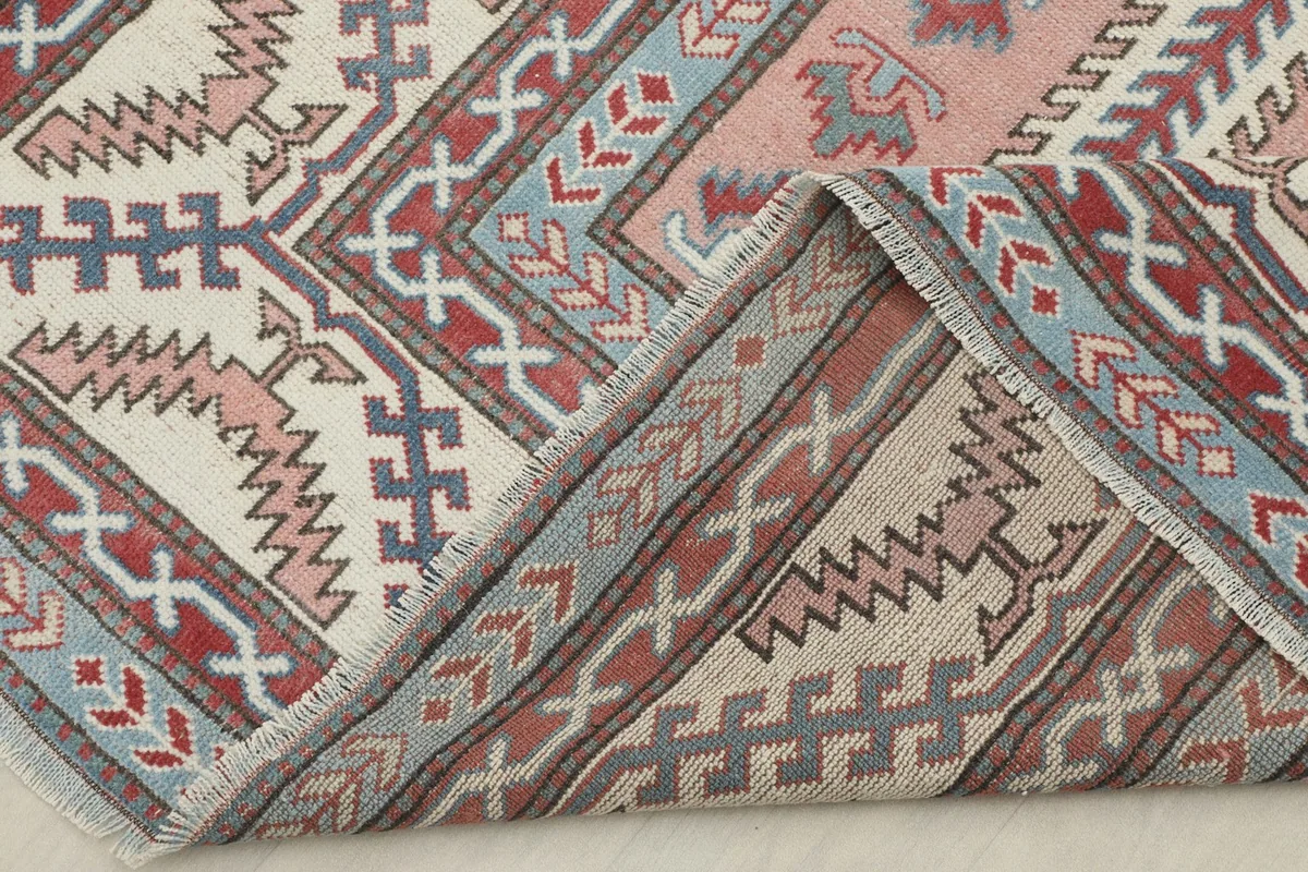 View of the rug's underside, showing the hand-knotted cotton foundation and wool pile construction