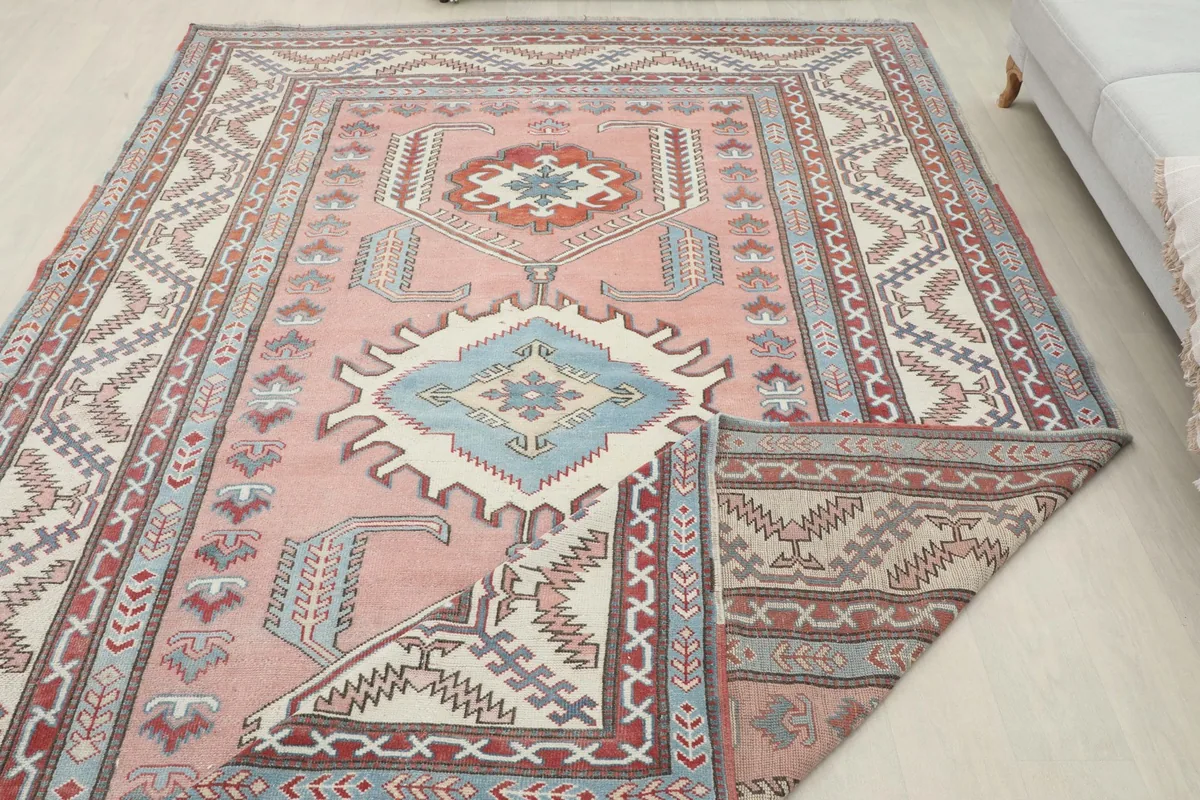 Rug corner folded back, revealing the hand-knotted construction and the reverse side pattern