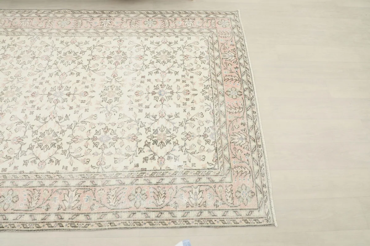 Top-down angled view of the corner of the vintage rug, showing the border details