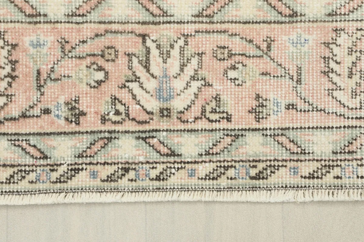 Close-up of the rose border with intricate floral and geometric designs and fringe