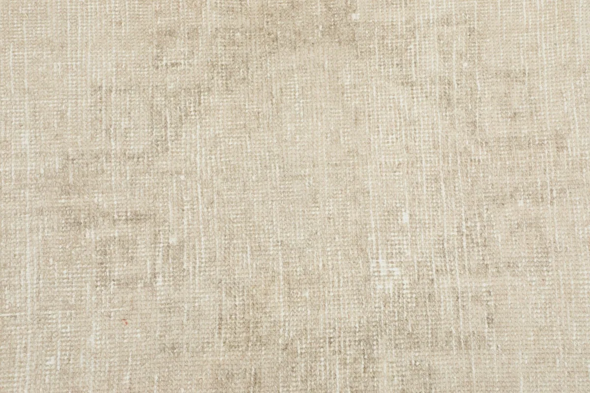 Texture shot of the low wool pile and hand-knotted weave, emphasizing the subtle color shifts and aged appearance.