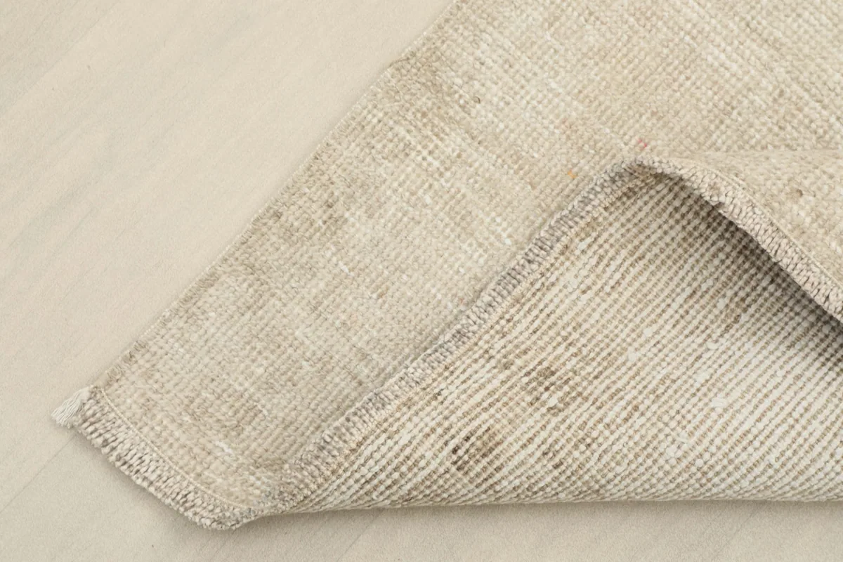 Corner view showing the back of the hand-knotted wool pile on a cotton foundation, revealing construction.