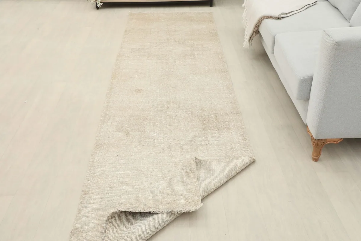 Runner rug partially folded in a room setting, displaying its flexibility and thickness.