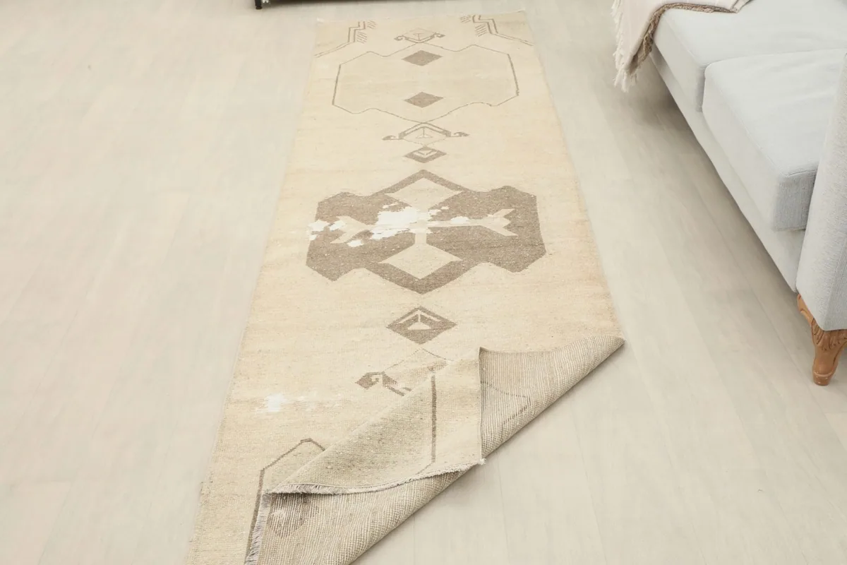Runner rug with one end folded back, showing the back of the rug and its thickness.