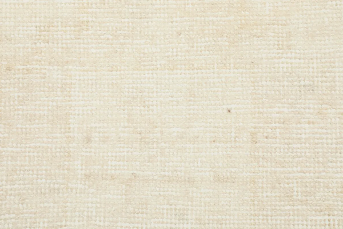 Detailed shot of the low wool pile and hand-knotted texture of the vintage ivory runner.