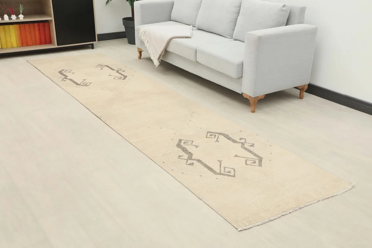 Angle view of the ivory and gray runner rug extending from a sofa in a contemporary room setting.