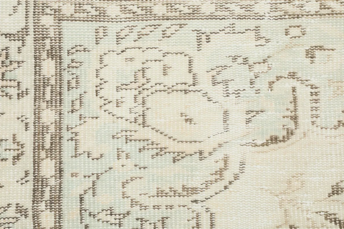 Close-up of the low wool pile and hand-knotted texture, showing the subtle color variations and wear.
