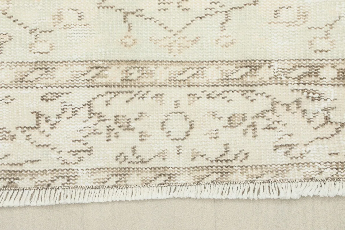 Detail of the rug's fringe and a section of the border, revealing the hand-knotted construction.