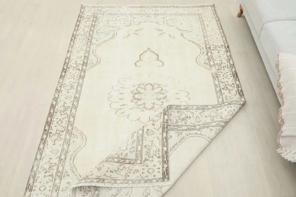 Overhead view of the rug with one corner gently folded, displaying the full design and foundation.