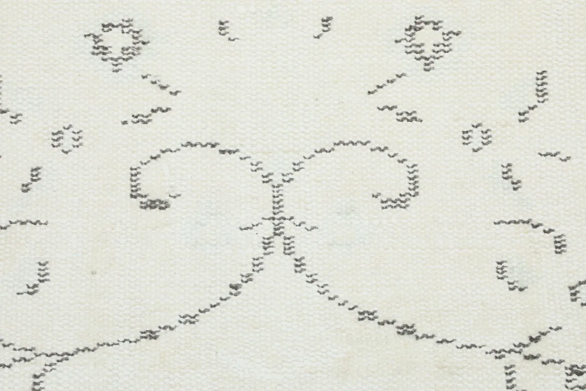 Detailed view of the intricate gray patterns and motifs on the rug