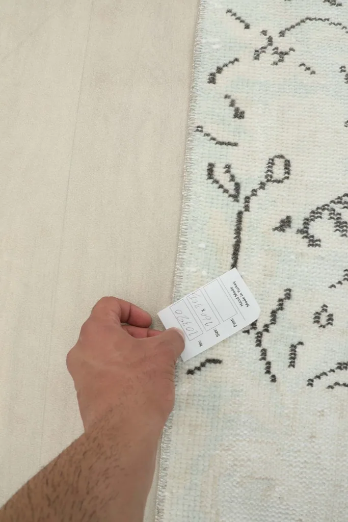 Hand touching the low wool pile of the professionally cleaned vintage rug