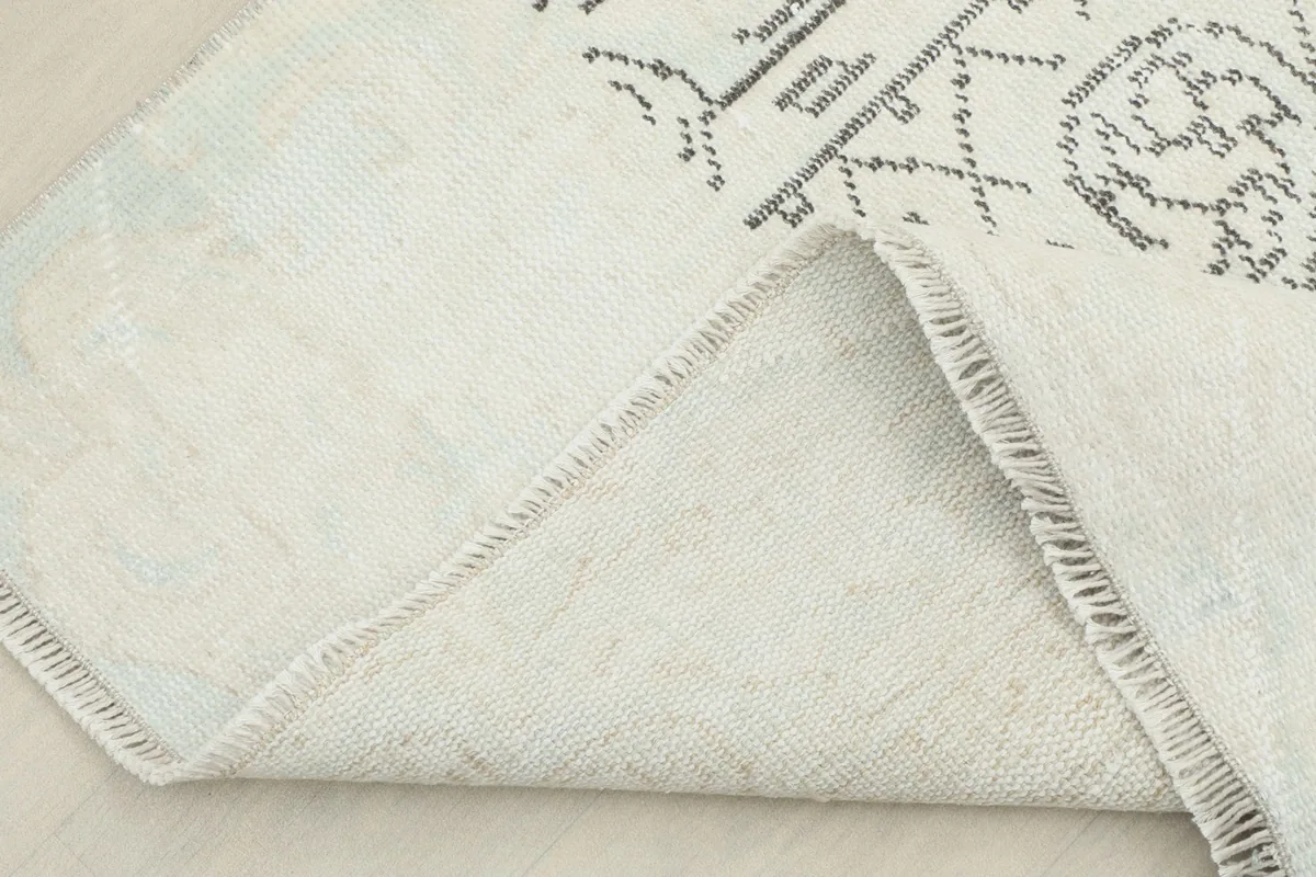View of the back of the hand-knotted rug, showing its cotton foundation