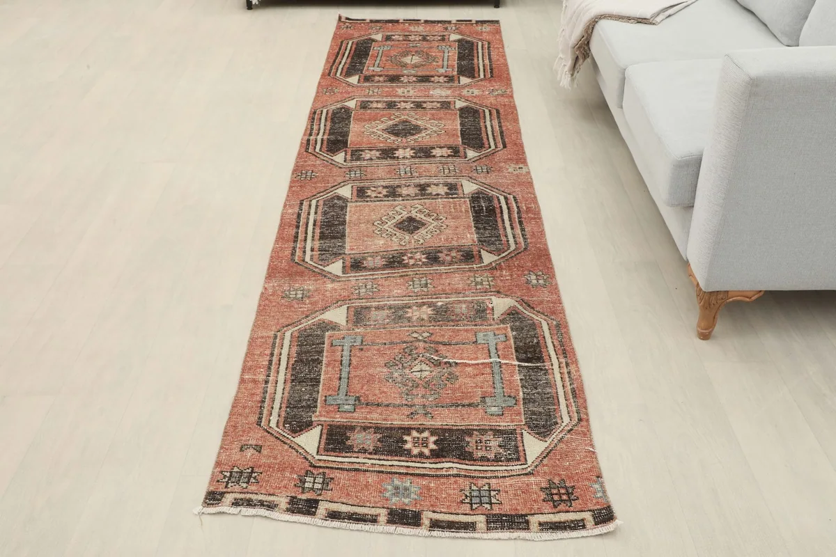 Full overhead view of the vintage Anatolian runner in a room setting, showcasing its complete design and length.