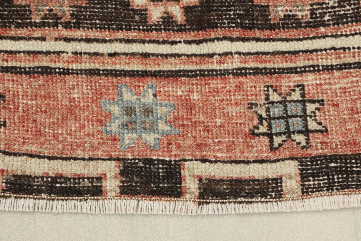 Close-up of the short, subtle fringe and the edge of the runner, showing the cotton foundation.