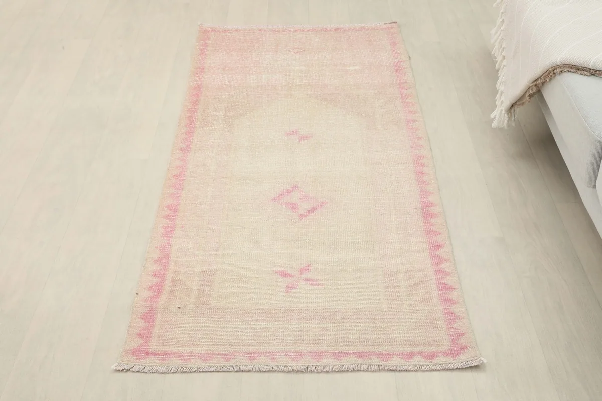 Overhead view of the ivory and pink rug placed next to a light-colored sofa