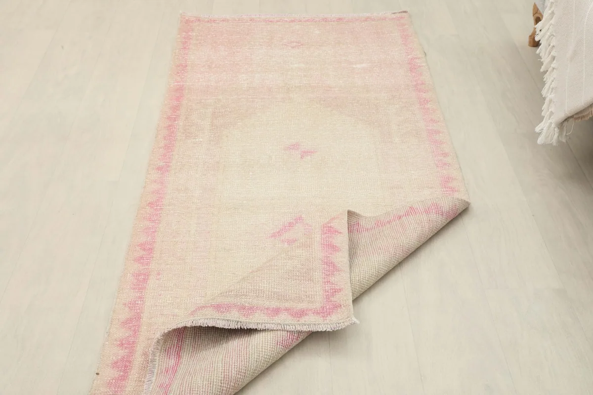 View of the rug with one corner folded back, showing the back of the rug