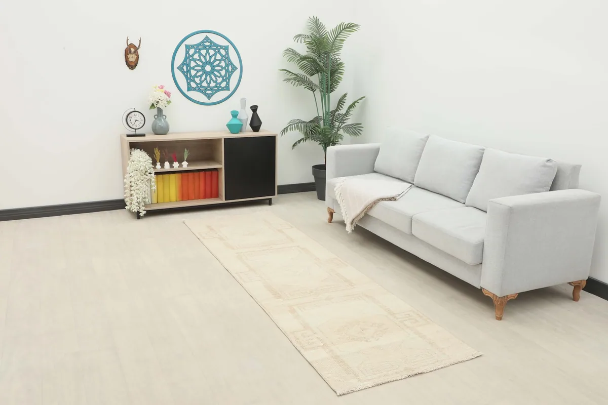Runner rug in a living room setting next to a couch and cabinet