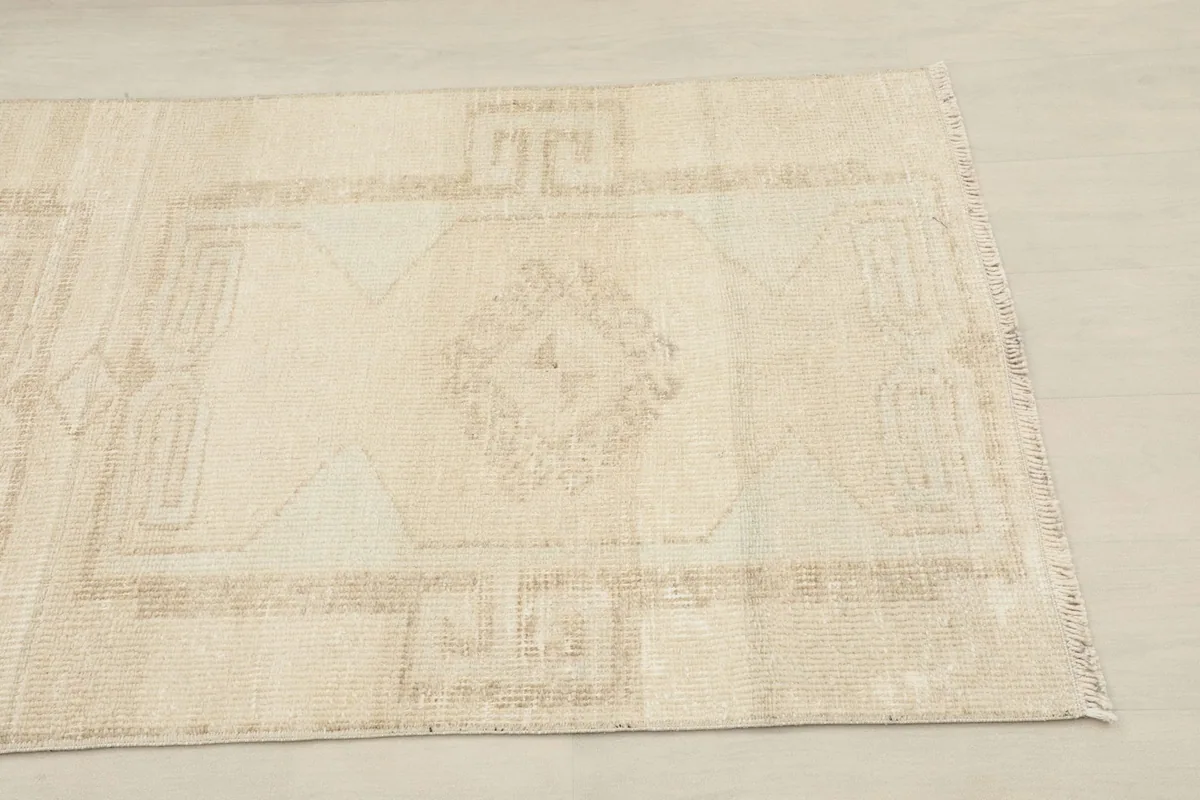 Close-up of the geometric pattern and cream color at one end of the rug